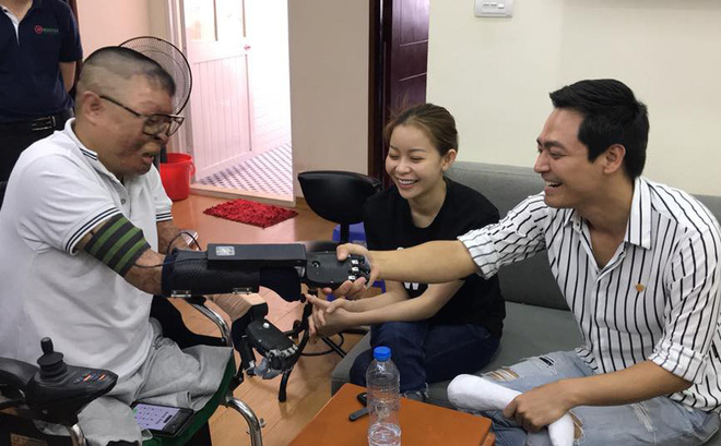 Dinh Van Duong (left) receives 3D printed bionic hands from MC Phan Anh (right)