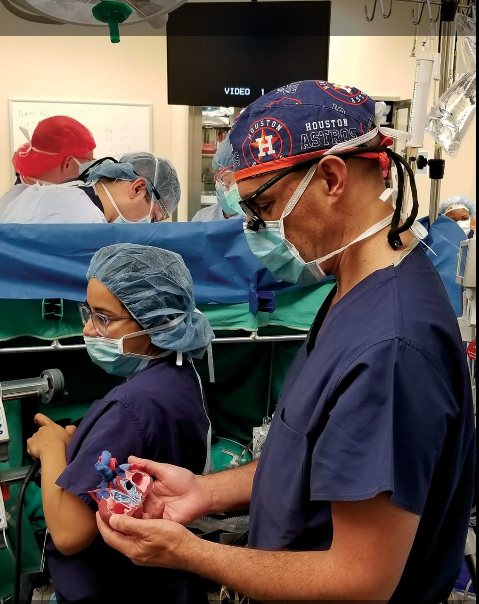 OpHeart's Dr. Jorge Salazar, the Chief of Pediatric and Congenital Heart Surgery at Children’s Memorial Hermann Hospital references a 3D printed patient-specific anatomical heart model in a operating room. Photo via OpHeart.